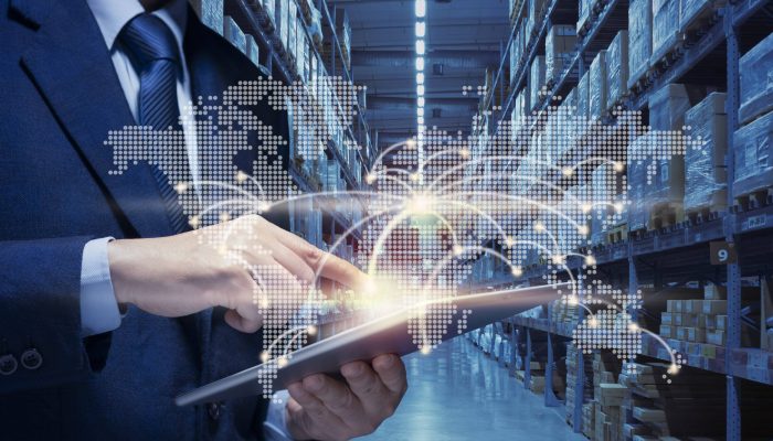 Businessman manager using tablet to plan, check, control of logistics transportation in country and Global. Man touch point of city connection line in world map to distribute product goods at warehouse